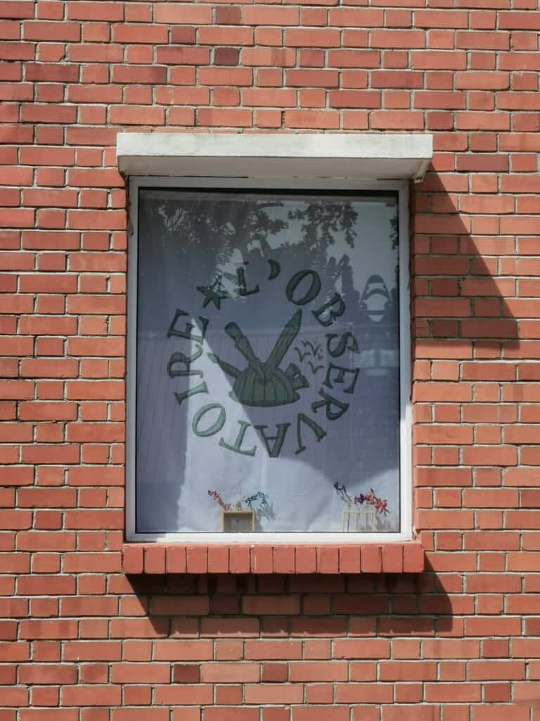 L'Observatoire: Window reflecting the green landscape in the Blue House International School building