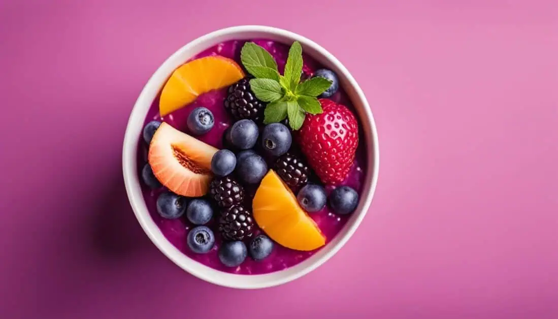 A vibrant bowl filled with assorted fruits and berries, set against a soft pink background, highlighting acai bowl options in Singapore.